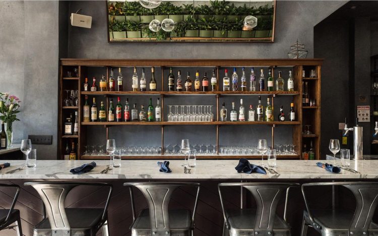 bar with metal bar chairs and back bar of liquor