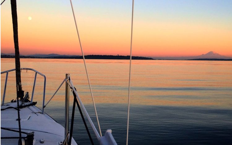 front of boat on water with sunset